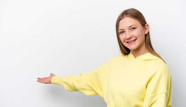Fiatal orosz nő elszigetelt fehér háttér kiterjeszti kezét oldalra meghívó jönni - Fotó, kép
