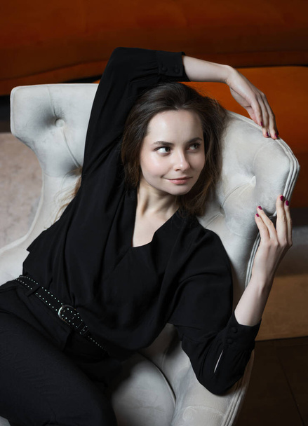 Beautiful young girl posing in a chic white armchair. - Фото, изображение