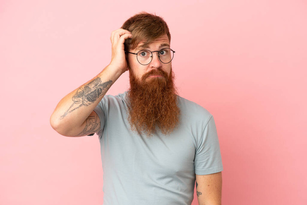 Young reddish caucasian man isolated on pink background with an expression of frustration and not understanding - Photo, Image