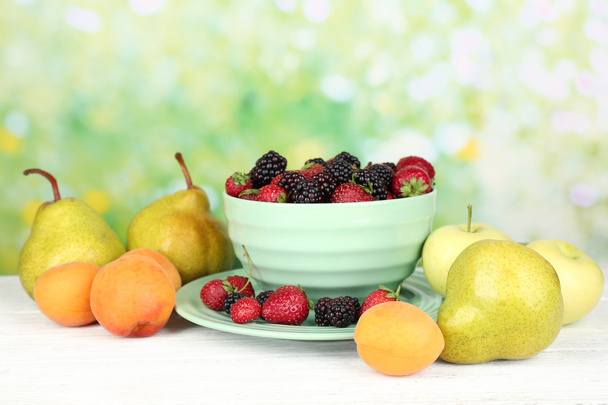 Ripe fruits and berries on table on bright background - Fotografie, Obrázek