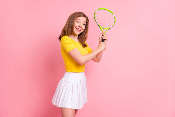 Profile side photo of young girl happy positive smile sportive play tennis training racquet isolated over pink color background - Фото, зображення