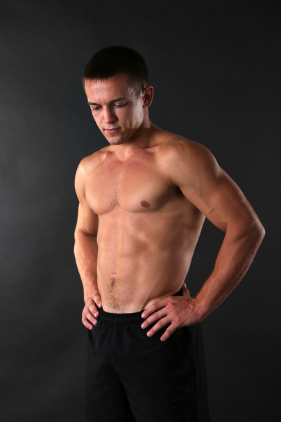 Handsome muscle young man on dark background - Φωτογραφία, εικόνα