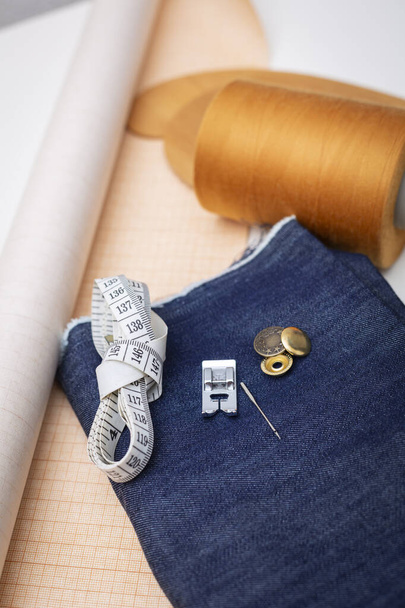 Tejido de mezclilla para costura y costura - curva de costura incluyendo pin, madeja de hilo, papel para patrón de costura.  - Foto, imagen