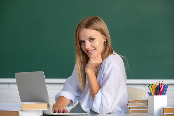 Student preparing exam and learning lessons in school classroom. Beautiful caucasian female student is studying in college remotely, distance learning, online education. - Foto, Imagem