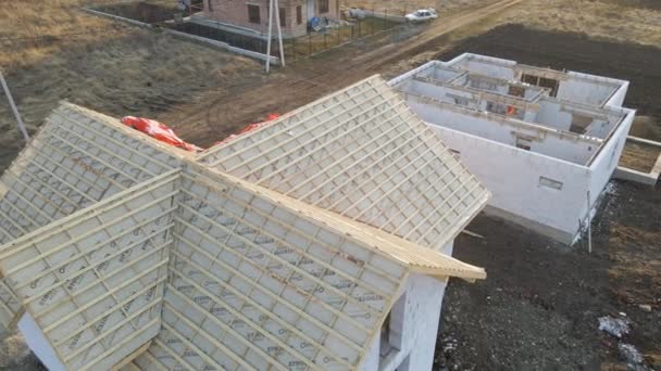Luftaufnahme des Rohbaus eines Privathauses mit Porenbetonwänden und Dachstuhl aus Holz im Bau - Filmmaterial, Video