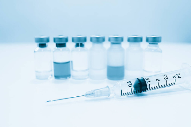 Flacon de médicament et seringue en plastique de 3 ml avec aiguille isolée sur le fond blanc
 - Photo, image
