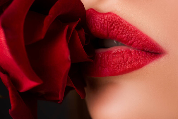 Close up of red glossy female lips. Beautiful woman lips with rose. - Fotó, kép