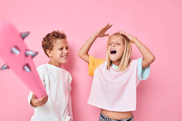 Cheerful boy and girl rubber pink baton toy fun - Valokuva, kuva