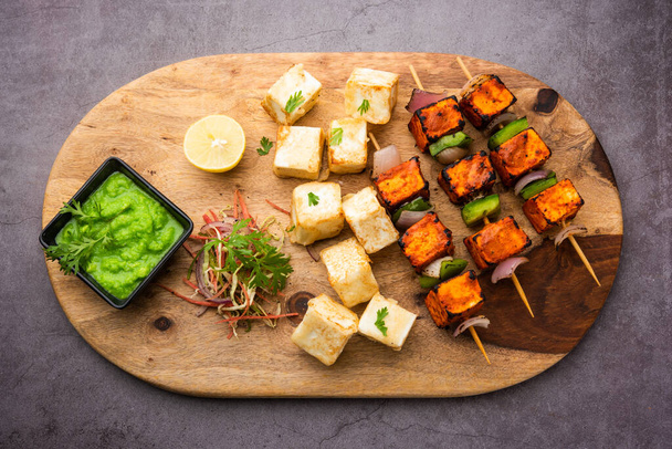 makhmali or Malai Paneer Tikka Kabab is a north indian starter food served with green salad and chutney - Photo, Image