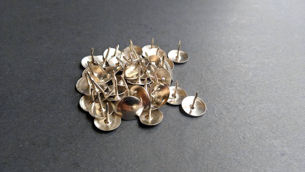 Set of metal thumbtack isolated on a black background, gold color in several variants - Photo, Image
