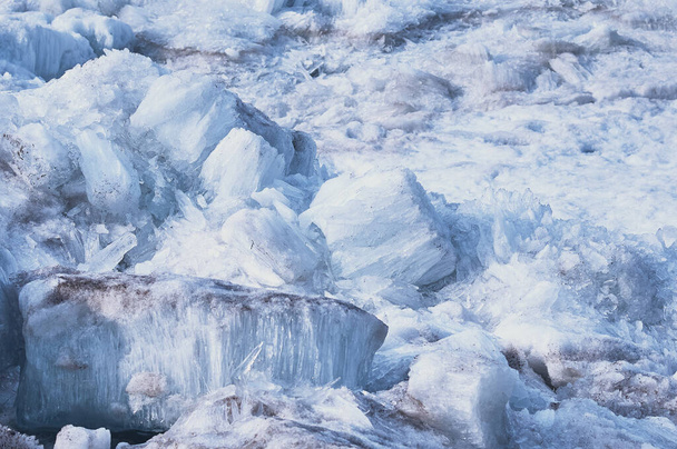 Roztapiający się lód. Kolumnowa i igłowo-podobna struktura kryształów. Kra lodowa na wiosnę nad brzegiem rzeki Amur. Z bliska. Duże bryły stałej wody. Skupienie selektywne. - Zdjęcie, obraz
