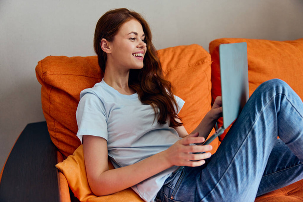усміхнена жінка ноутбук на колінах вдома на дивані розваги Стиль життя
 - Фото, зображення