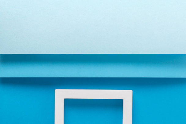 Square podiums on a background of blue cardboard design of folded paper material. Top view, flat lay. - Photo, Image