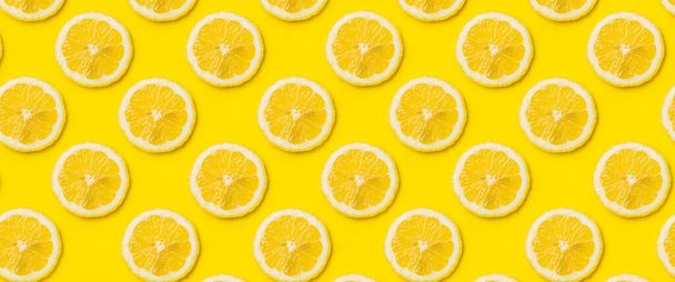 Sarı arka planda olgun limon dilimlerinin olduğu bir arka plan. Üst manzara, düz yatış. Pankart. - Fotoğraf, Görsel