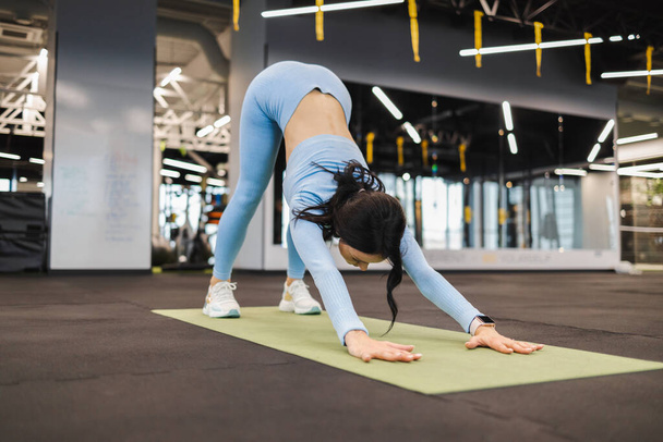 Fitness girl in downward dog pose. Woman doing gymnastic - Photo, Image