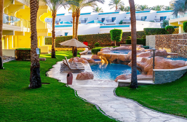 Sharm el sheikh, Égypte - 03 décembre 2019 : Eau claire d'une piscine propre et chaises longues dans une station tropicale de luxe à Sharm El Sheikh, péninsule du Sinaï, Égypte - Photo, image