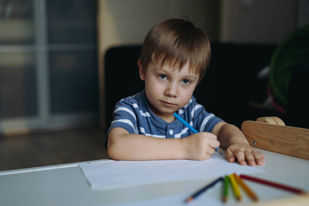 Adorable little toddler boy passionately drawing with color pencils. Image with selective focus . High quality photo - Photo, image