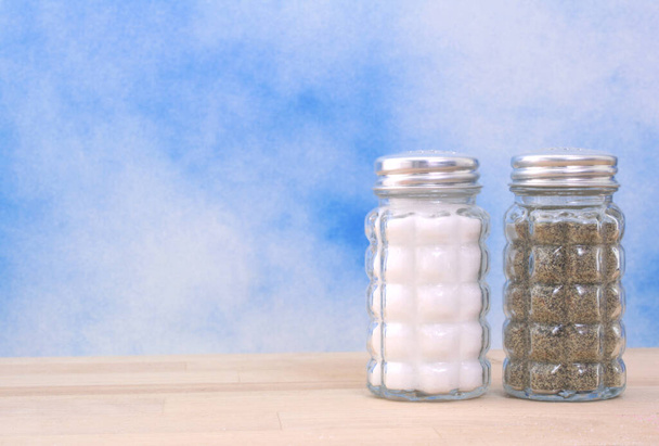Salt and Pepper Shaker on Blue Background - 写真・画像