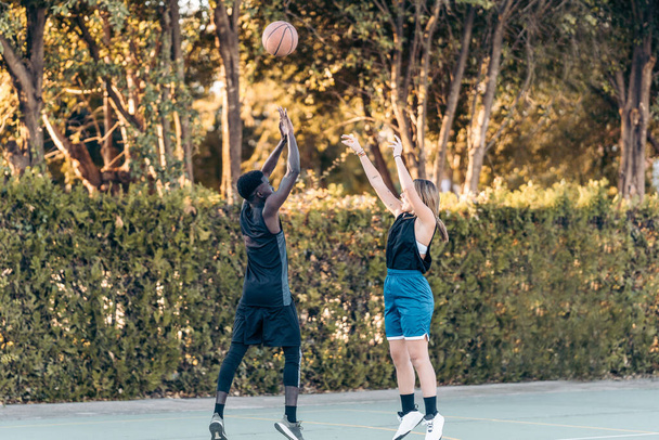 Two friends fighting for a ball while jumping in a basketball match - Photo, Image