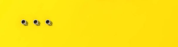 three white cups of coffee on yellow background. view from above. horizontal image. Banner for insertion into site. 3D image. 3D rendering. - Zdjęcie, obraz