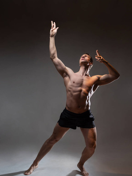 A young muscular man in an expressive pose. Beautiful muscles. - Fotoğraf, Görsel