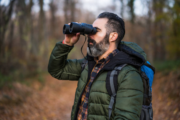 Image of man hiking and using binoculars. - Foto, Bild