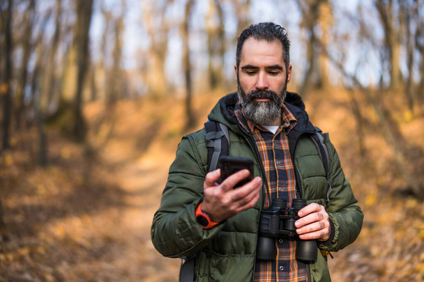 Image of hiker using phone while spending time in nature. - Fotó, kép