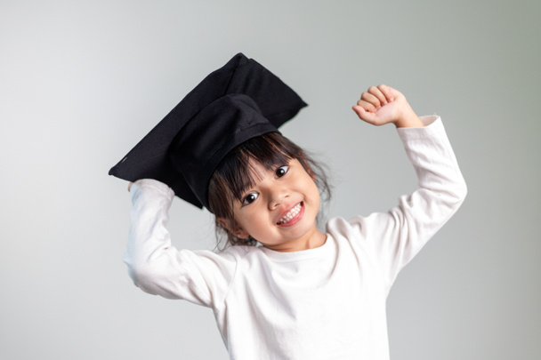 Happy Asian school kid graduate in graduation cap - Zdjęcie, obraz