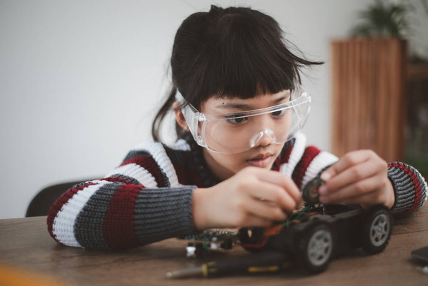 Little girls having fun in a workshop coding robot car - Photo, Image