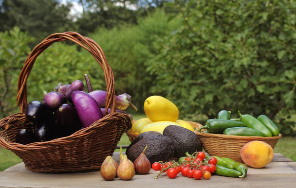 Летний урожай овощей - баклажаны, авокадо, вишневый помидор плюс инжир и корейская дыня - Фото, изображение