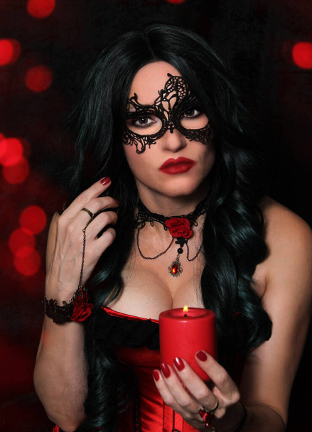 Woman in Red Corset holding Candle With Red Bokeh - Photo, Image