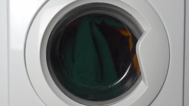 Renkli çamaşırları yıkayan bir çamaşır makinesinin yakın çekimi.. - Video, Çekim