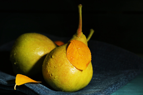 Ripe tasty pears on wooden table, on dark background - Foto, Bild