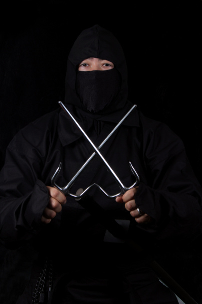 Азиат в костюме ниндзя и с оружием в руках - Фото, изображение