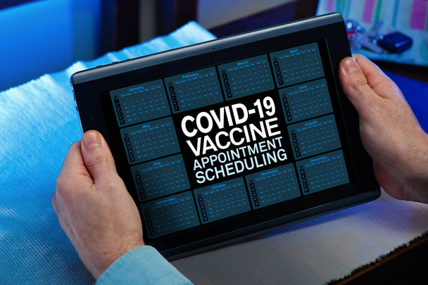 Ο άνθρωπος προγραμματίζει το ραντεβού στο ψηφιακό ημερολόγιο για τον εμβολιασμό του κατά του Coronavirus. Ασθενής με ψηφιακό δισκίο στον ιστό του Προγραμματισμού Ραντεβού Εμβολίου COVID-19 - Φωτογραφία, εικόνα