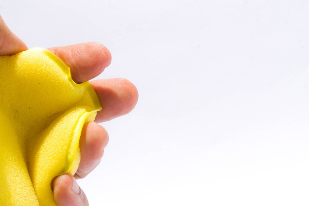 play yellow sponge in hand with an isolated white background. - Fotó, kép