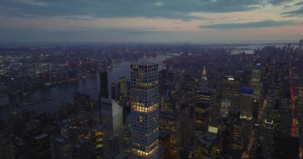 Emelt kilátás a tetejére 432 Park Avenue magas modern lakás felhőkarcoló tornyosul a belváros felett alkonyatkor. Légi panoráma az esti városra. Manhattan, New York City, Amerikai Egyesült Államok - Felvétel, videó