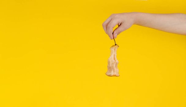 stub of pear in hand on yellow background - Foto, Imagen