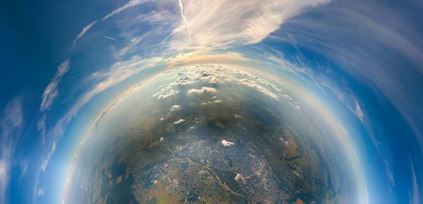 Antenni näkymä lentokoneen ikkunasta korkealla pieni planeetta kaukainen kaupunki peitetty ohut sumu ja kaukaisia pilviä illalla - Valokuva, kuva