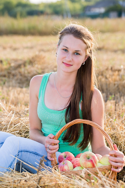 Teen girl with a basket of apples in  field - Zdjęcie, obraz