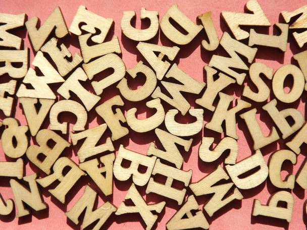 letras de madera del alfabeto inglés en ante rosa como fondo - Foto, imagen