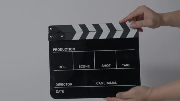 Clapper board. Close up hand and film making clapperboard isolated on background studio. Movie or video production concept. Clappers board Shuts. Film crew holds film slate in hand for video recording - Footage, Video