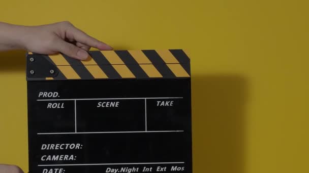 Κομψός πίνακας. Κοντινό πλάνο χέρι και ταινία κάνοντας clapperboard απομονώνονται στο στούντιο υποβάθρου. Έννοια κινηματογραφικής ή τηλεοπτικής παραγωγής. Κλακέτες. Κλακέτες. Κινηματογραφική ομάδα κρατά σχιστόλιθο στο χέρι για την εγγραφή βίντεο - Πλάνα, βίντεο