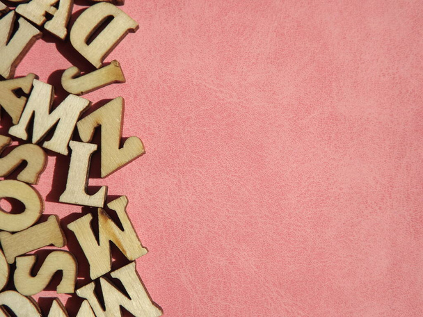 Holzbuchstaben des englischen Alphabets auf rosa Wildleder als Hintergrund - Foto, Bild