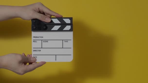 Κομψός πίνακας. Κοντινό πλάνο χέρι και ταινία κάνοντας clapperboard απομονώνονται στο στούντιο υποβάθρου. Έννοια κινηματογραφικής ή τηλεοπτικής παραγωγής. Κλακέτες. Κλακέτες. Κινηματογραφική ομάδα κρατά σχιστόλιθο στο χέρι για την εγγραφή βίντεο - Πλάνα, βίντεο