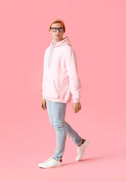 Young guy in stylish hoodie on color background - 写真・画像