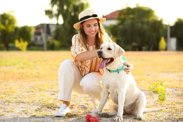 Woman with cute Labrador outdoors on summer day - Photo, Image