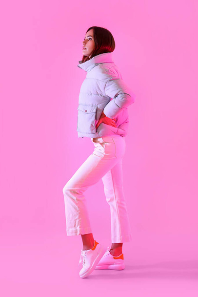 Mujer bastante joven en ropa de abrigo con estilo en el fondo de color - Foto, Imagen