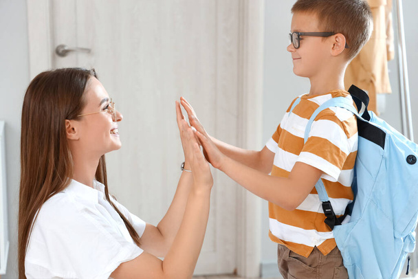 Woman and her little son giving each other high-five before school - Φωτογραφία, εικόνα
