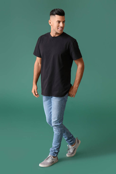 Όμορφος νεαρός άνδρας σε κομψό t-shirt σε φόντο χρώμα - Φωτογραφία, εικόνα